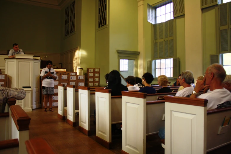 a woman is giving a lecture to a group of people