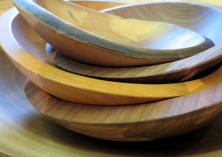 several wood bowls with handles stacked on top of each other