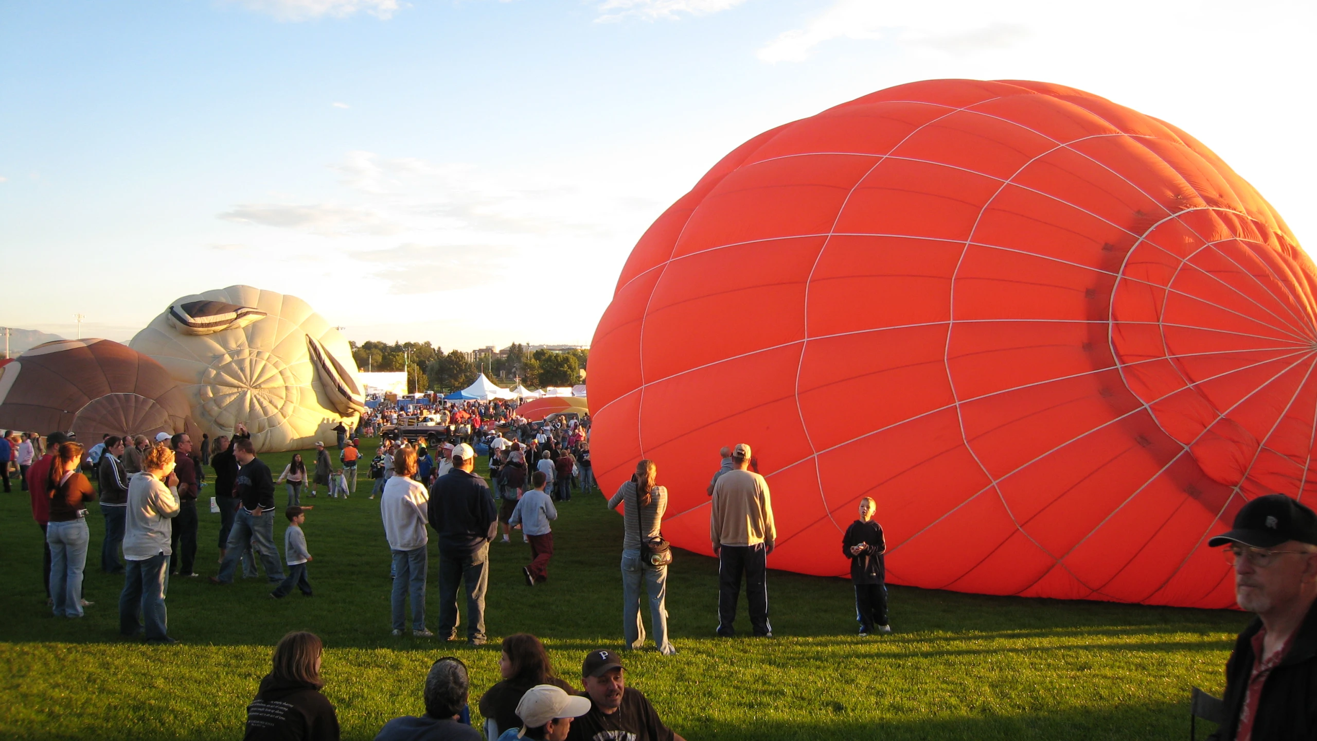 a large group of people standing near a huge balloon