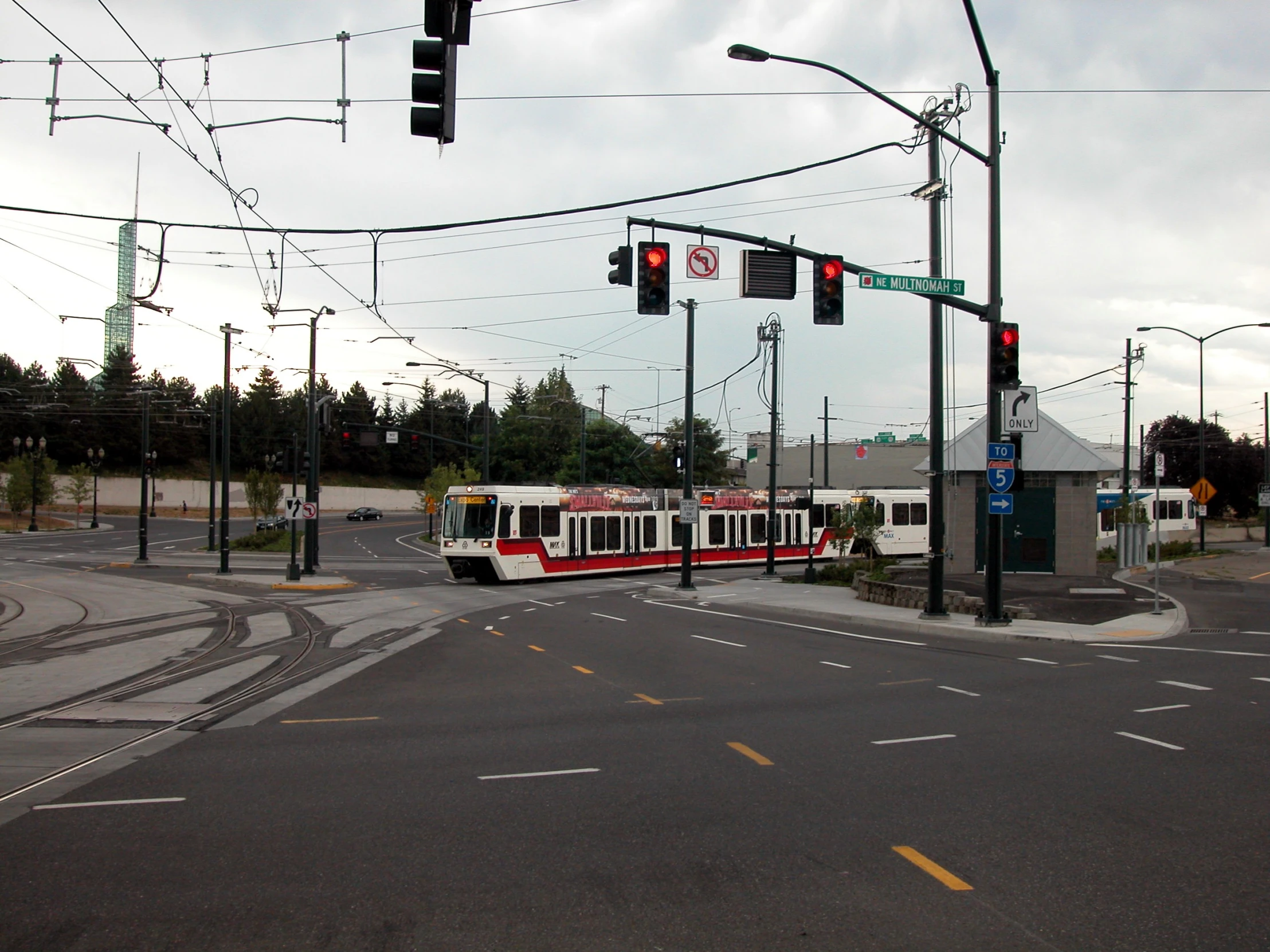 a long passenger train sitting at a traffic light