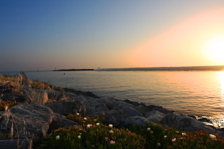 a rock cliff that leads into a body of water