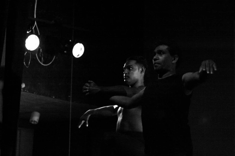 two people dance in a dark room
