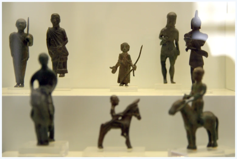 figurines are shown displayed in glass cases