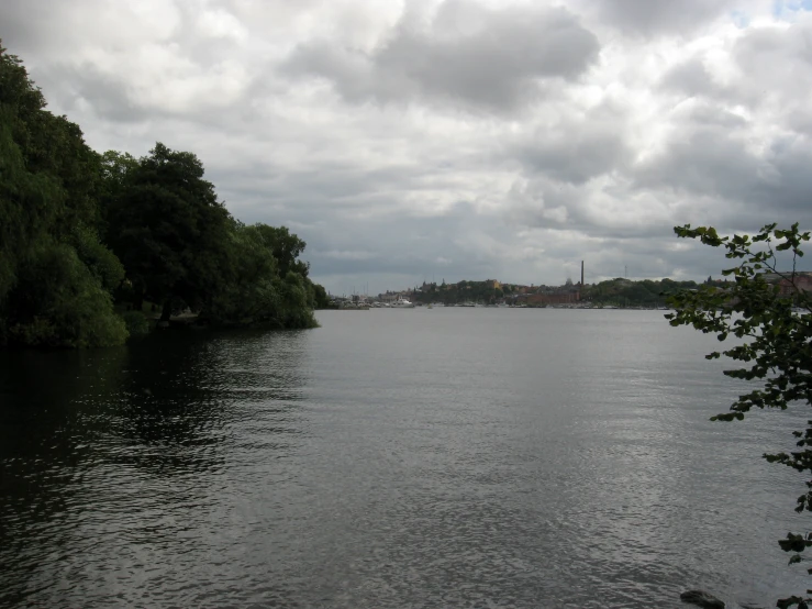 cloudy skies over the river near a small park