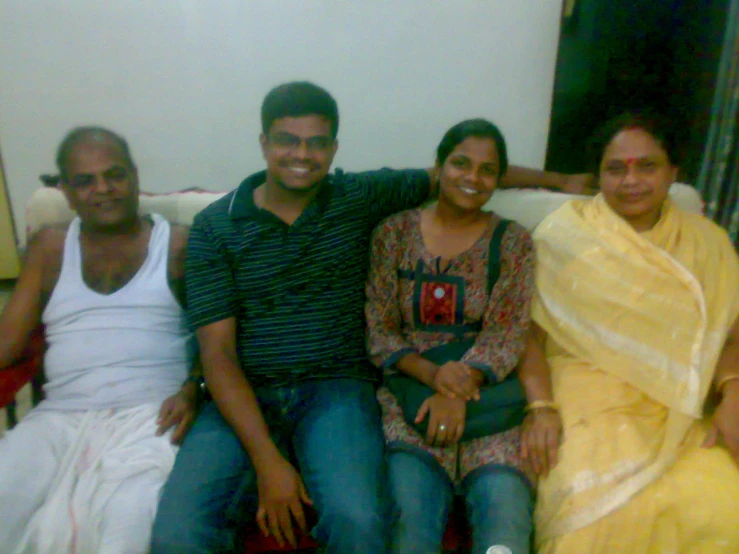 three people sit close together on a sofa