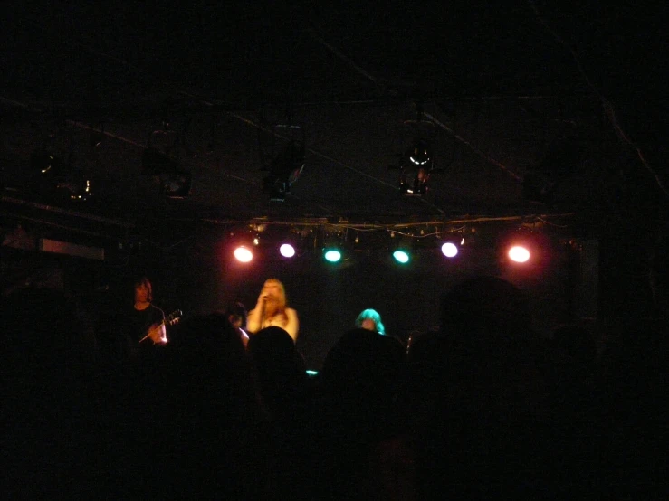 a dark stage with lights and people playing