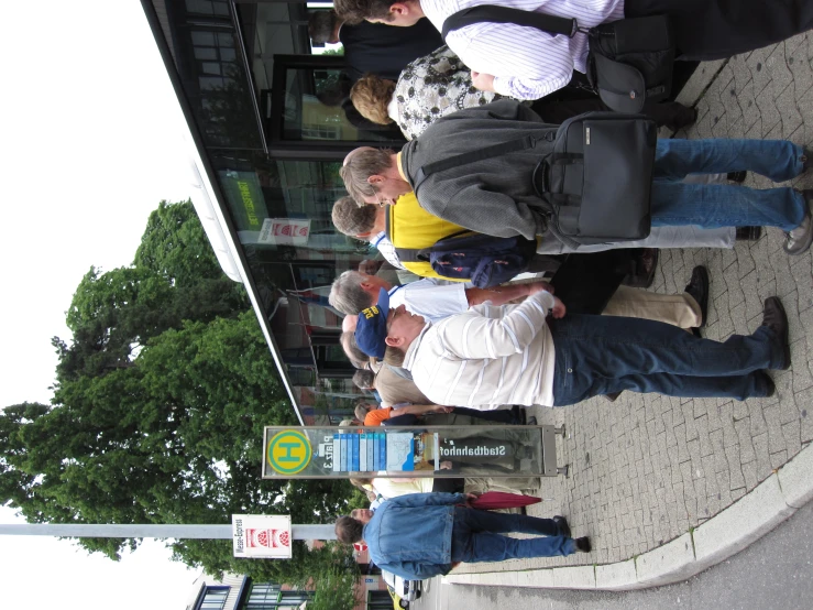 a group of people standing on the sidewalk next to a bus