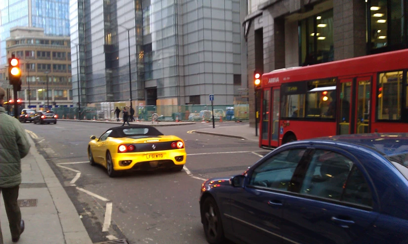 the yellow car is driving down the road