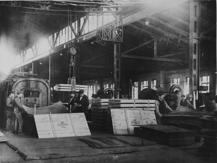 men in a factory work on steel sheets