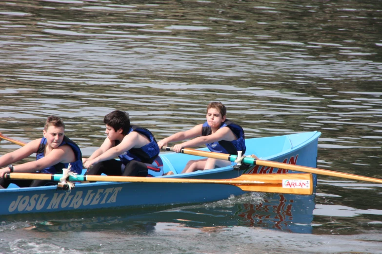 three people are in a blue canoe