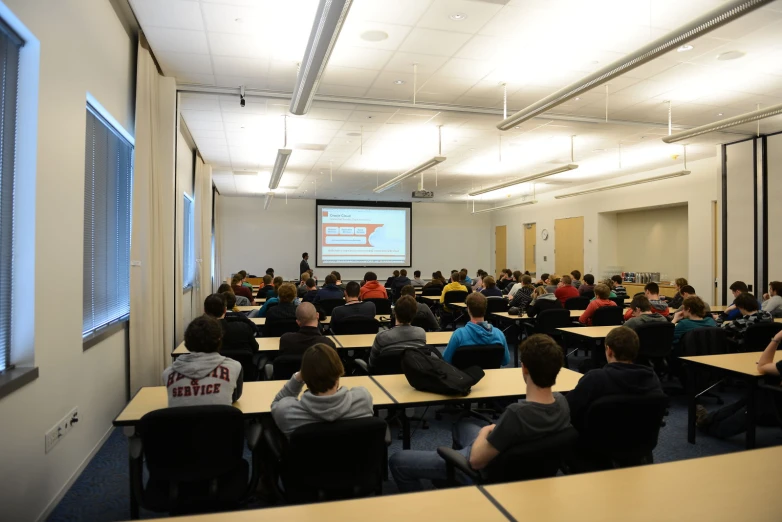 a group of people are sitting in front of a class