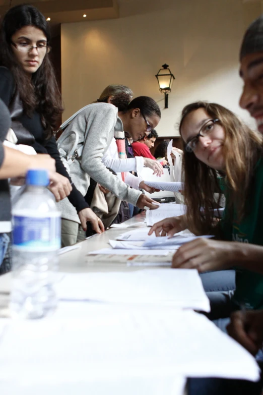 a group of women and man with paper on the table