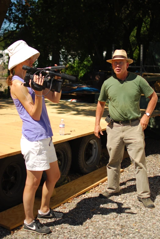 a woman standing next to a man wearing a green shirt