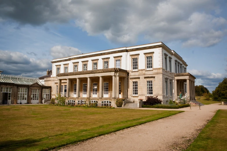 the large white building is surrounded by green grass