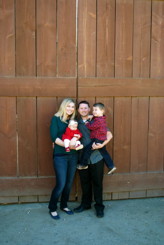 three people standing together and holding their baby boy