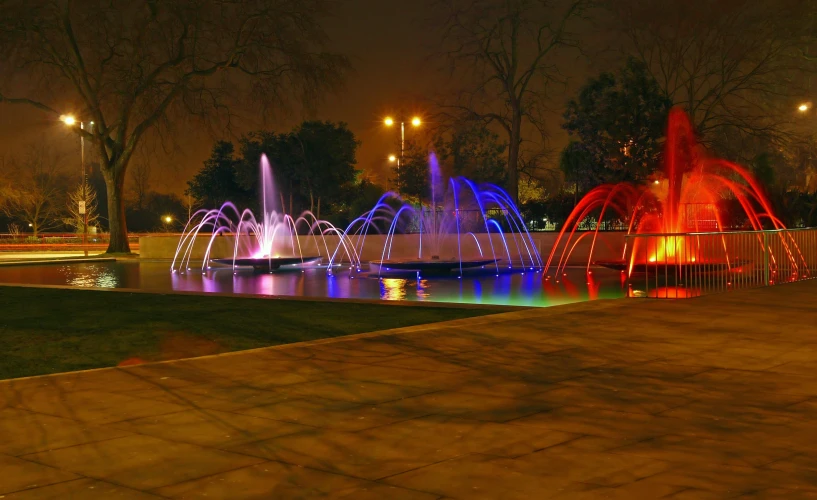 lit fountains show brightly in a park during the night