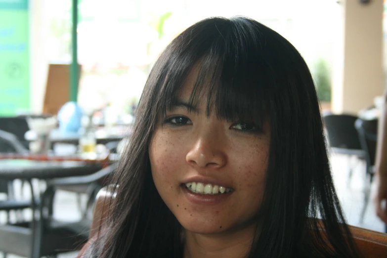 a woman smiling and sitting at a table