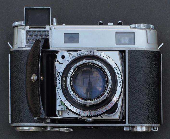 a silver and black vintage camera sitting on top of a table