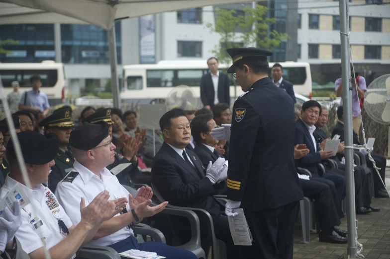 a uniformed military officer gives instructions to some officers