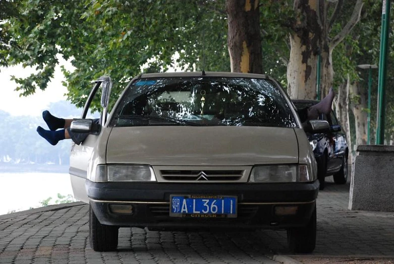 a small car parked next to some trees