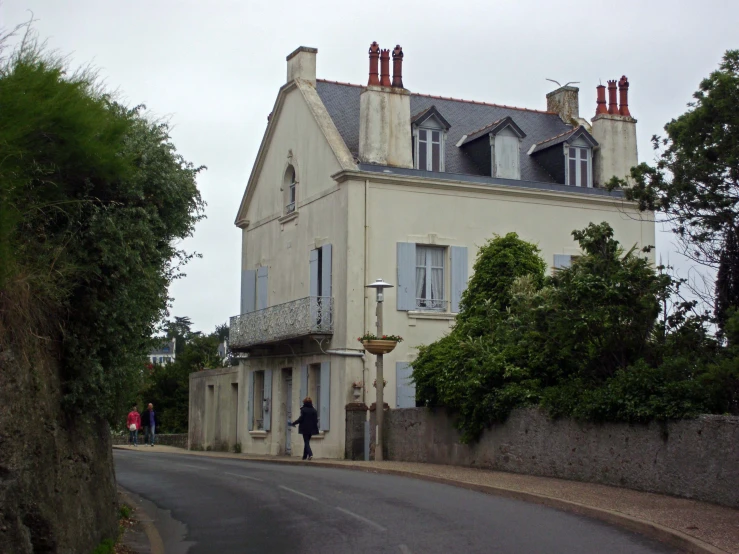 a man walking a bike down a street past a house