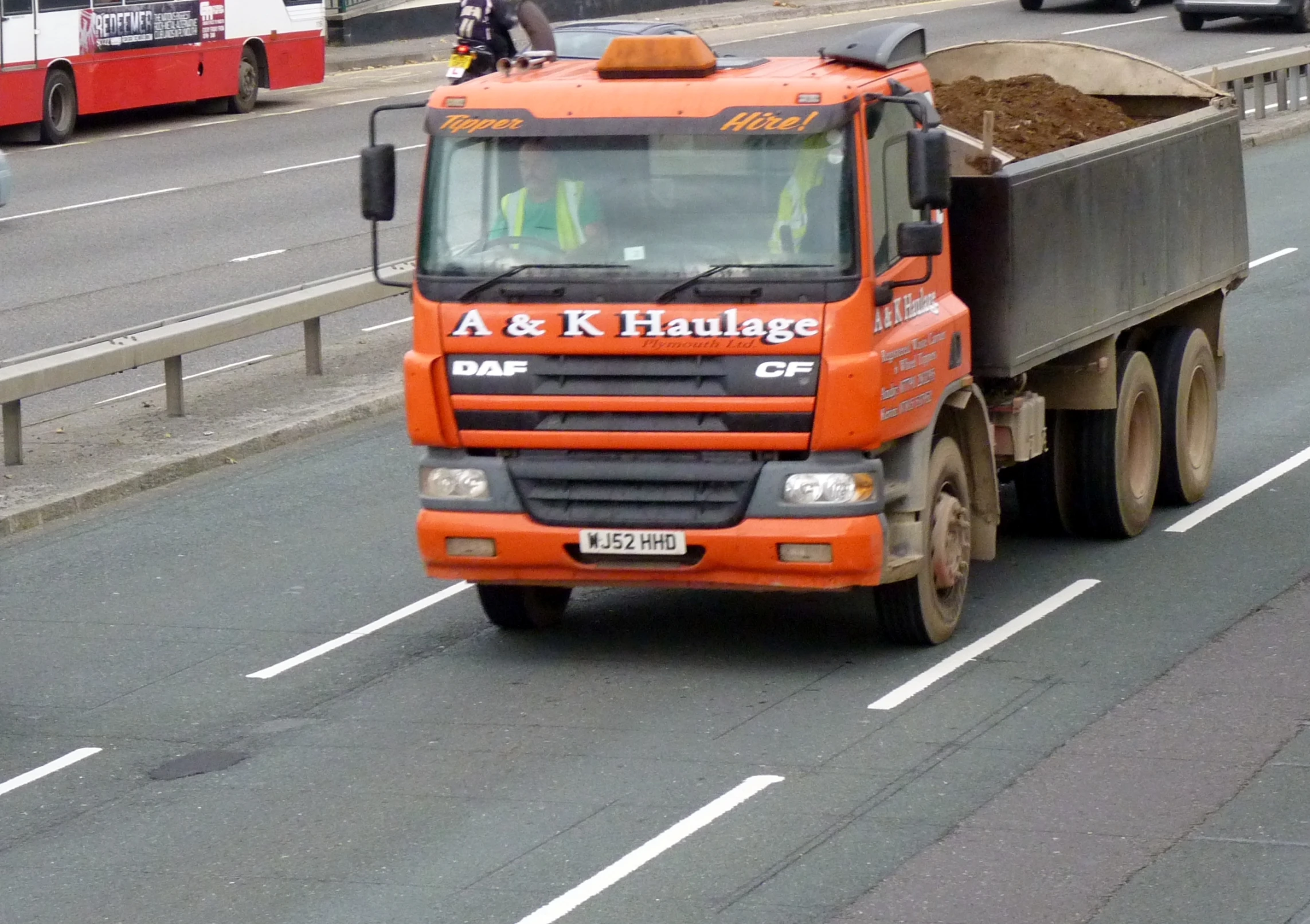 an orange dump truck traveling down the road