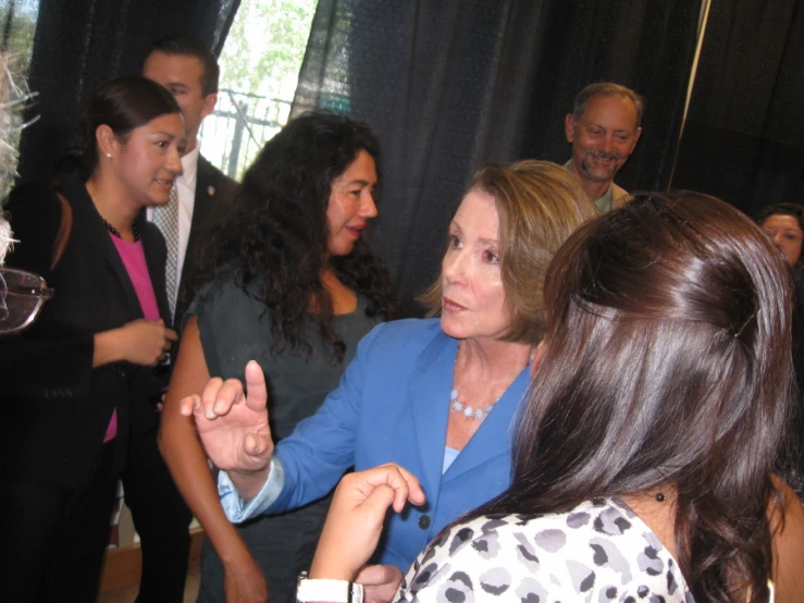 several people in a group having a conversation and drinking wine