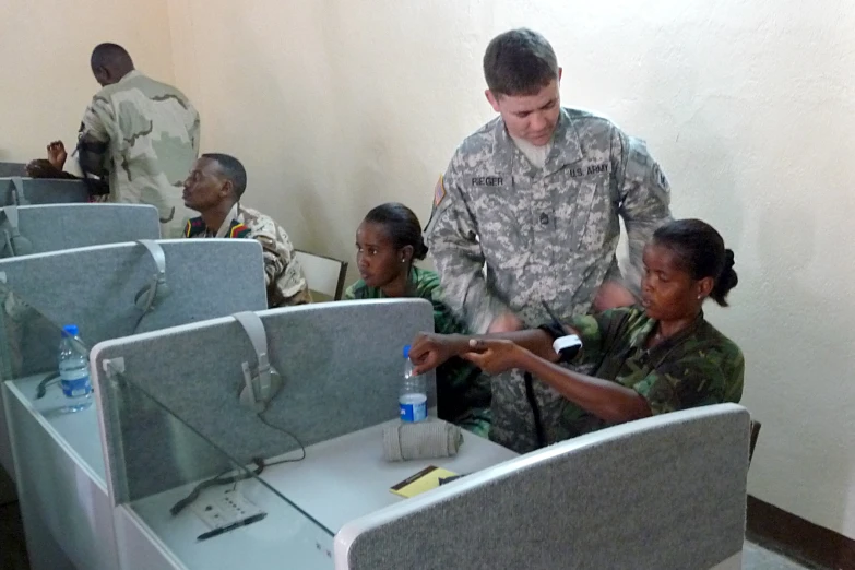 military personnel in uniform looking at soing on a table