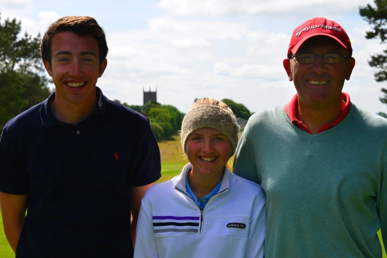 two guys and a girl posing together on the golf course