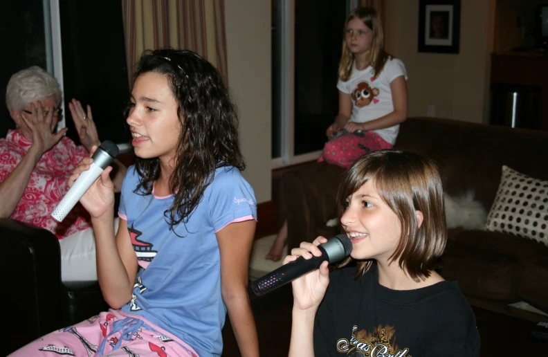 two women are singing with karaoke and singing into a microphone