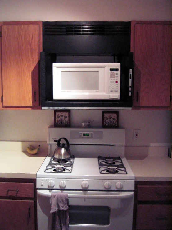 a microwave oven above a white stove top