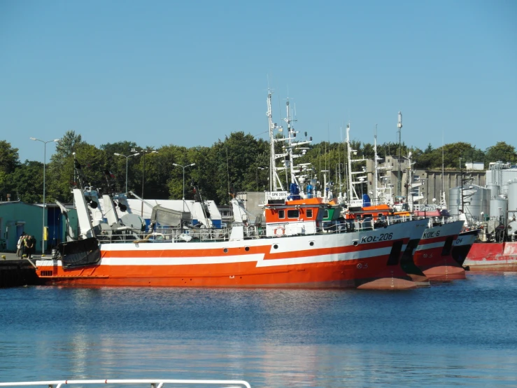 an orange and white boat is docked on the water