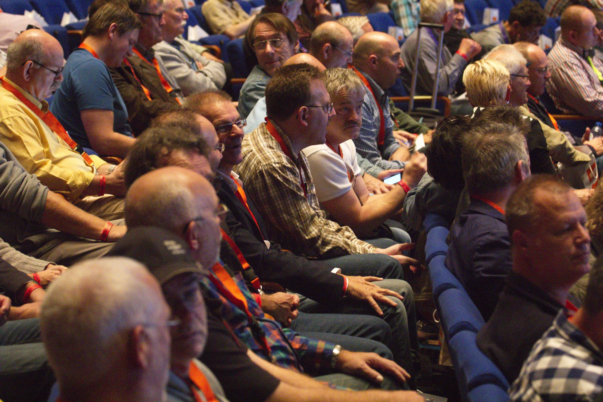 a group of people are sitting in an auditorium looking around