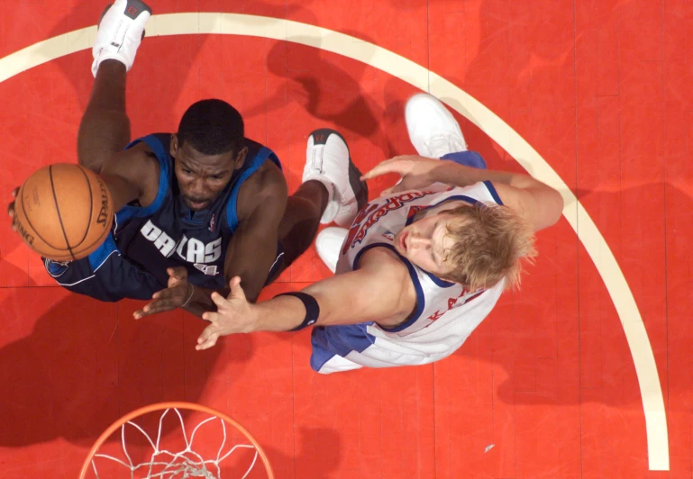 a couple of men playing basketball against each other