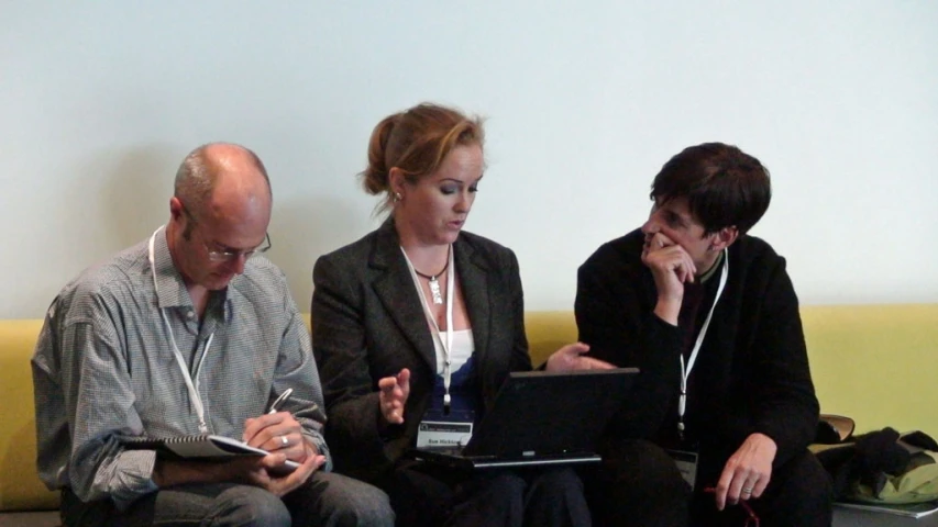 three people are on the couch looking at their laptops