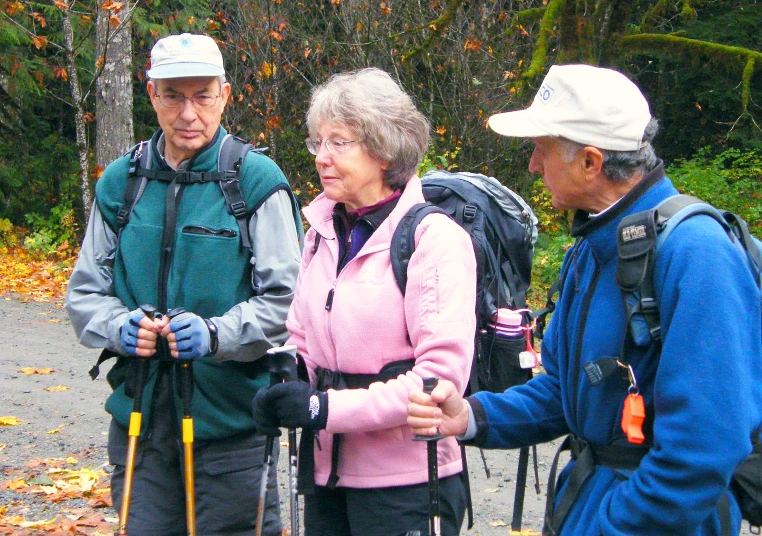 three people are talking while standing on the trail