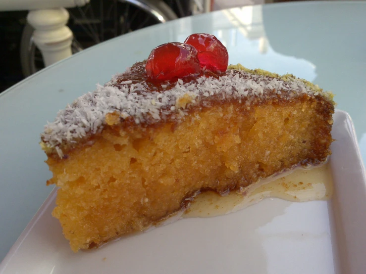 a slice of cake with icing and a raspberries on top