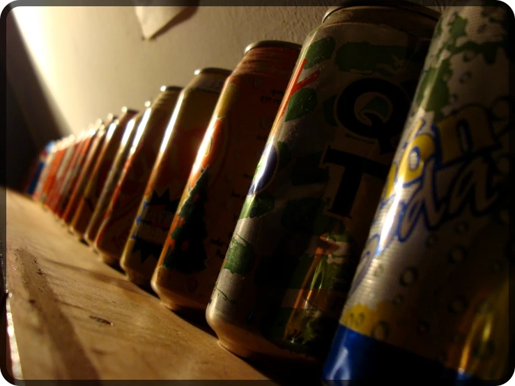 several stacks of bottles sitting on a wooden shelf
