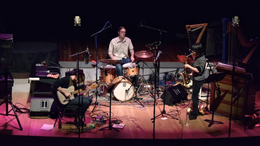 a band performs in front of a microphone and guitar player