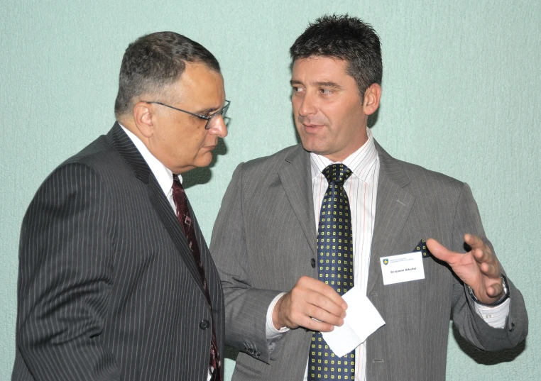 two men who are dressed up and one is talking