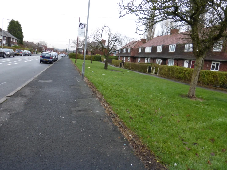 this is a street with parked cars and homes