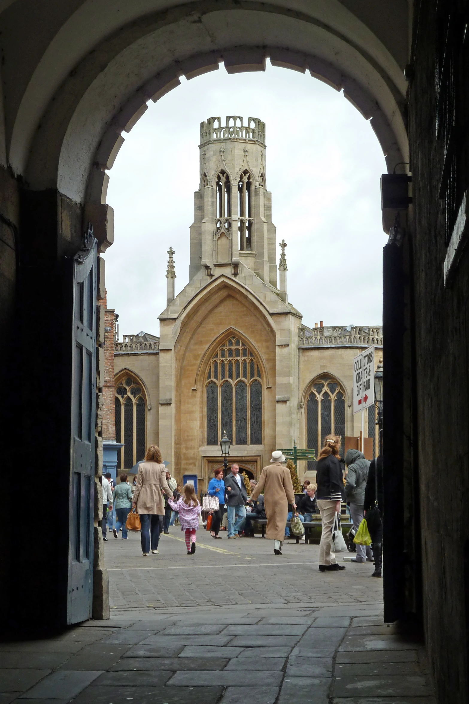 people walking around an archway in a building