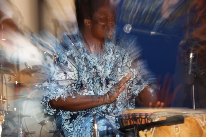 man with hand on drum with lights coming down behind him