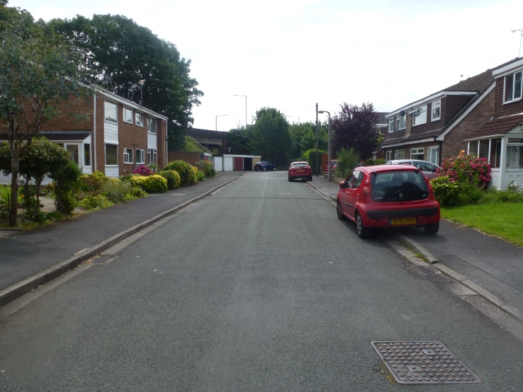 a red car is parked on a quiet street