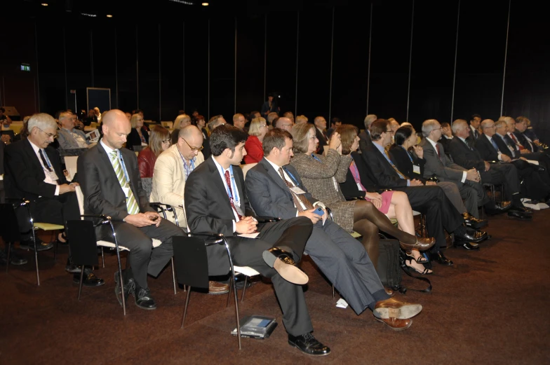 an audience at a seminar in suits and ties