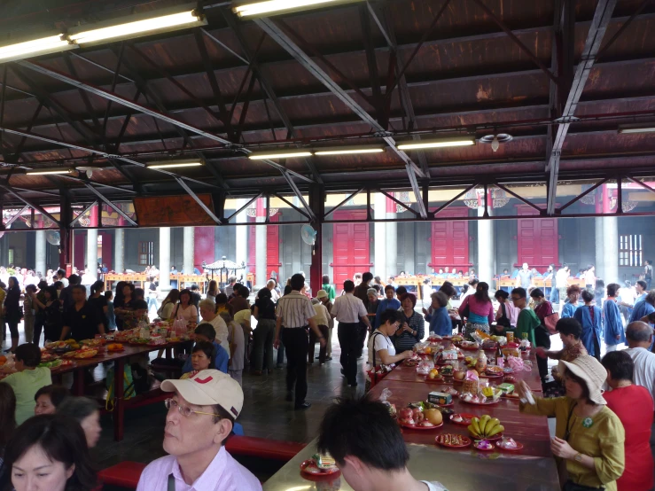 a group of people standing around tables full of food