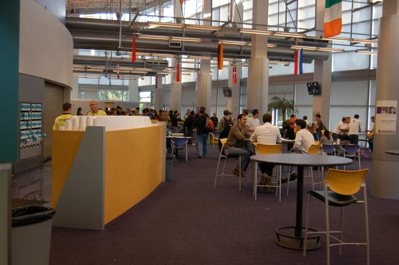 people sitting at table tables and chairs in an open area