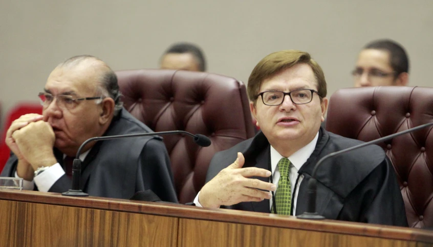 two men sitting at a desk during a courtroom