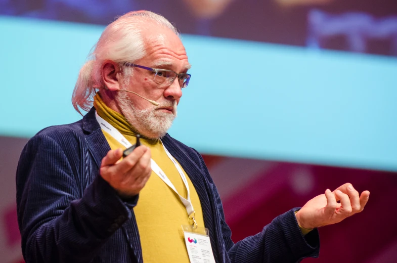 a man is standing and talking on stage