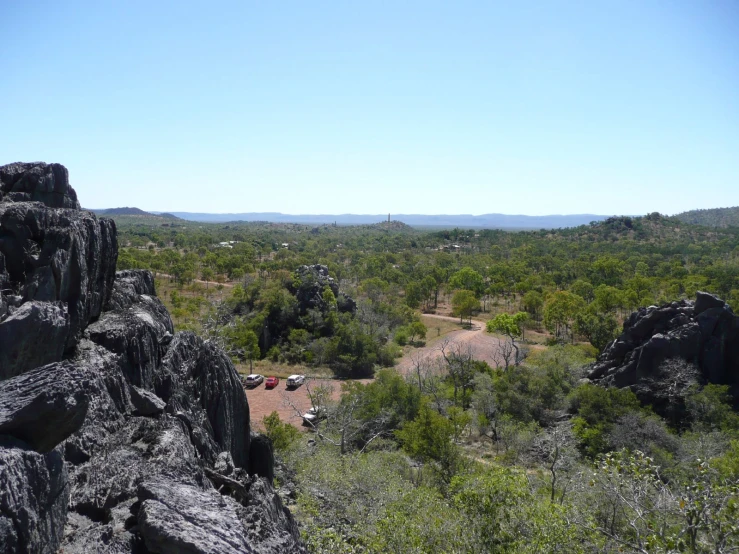 view looking down over green area with trees and rock formations